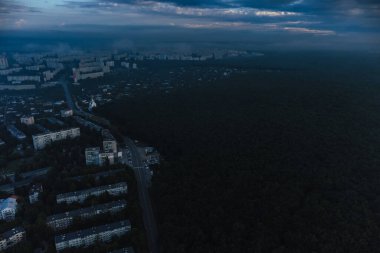 Yaz kenti yerleşim bölgesinde mavi renkli sabah bulanık manzarası. Ukrayna 'nın Harkiv caddeleri yakınlarındaki ormanın üzerindeki hava bulutları