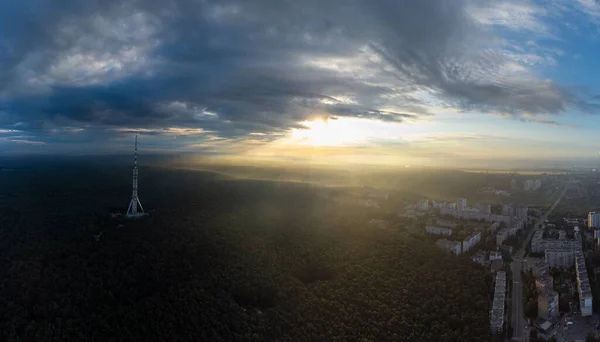 住宅街や風光明媚な曇りの空の近くの森の中の電気通信塔のアンテナで空中パノラマの日の出の朝の都市ビュー ウクライナのハリコフ — ストック写真