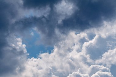 High layered white and gray epic clouds on blue sky. Heavenly cloudscape background