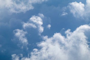 High layered white epic clouds on blue sky. Heavenly cloudscape background