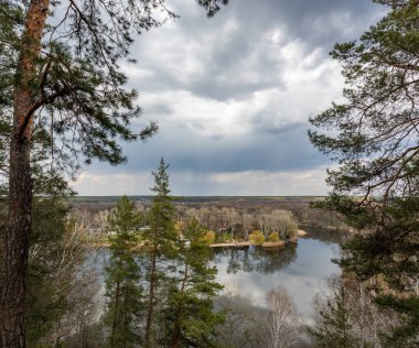 Scenic river bank with pine trees and rainy cloudscape. Cossack mountain, Korobovy Hutora (Gomilshanski forest, Koropove village) on Siverskyi Donets River in Ukraine