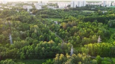 Aerial flying above cable car attraction at sunset in green summer Kharkiv city popular recreation park, Sarzhyn Yar. Recreation area in city center