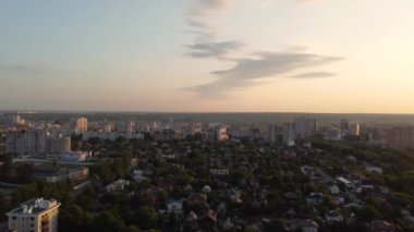 Greenery in city park district at sunset, aerial pan left to right view from drone. Recreation area in Kharkiv near residential buildings