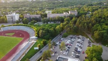 Aerial view of Kharkiv city center streets near Gorky Park, stadium and residential multistory buildings with scenic sunset light in summer