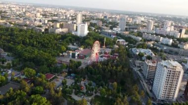 Attractions recreation area with greens in sunset light. Aerial fpv tilt footage, evening view in Kharkiv city center, Park of Maxim Gorky