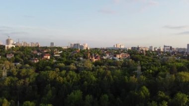 Aerial evening view from fpv drone on green Kharkiv city center district near recreation park Sarzhyn Yar. Residential area in sunset light