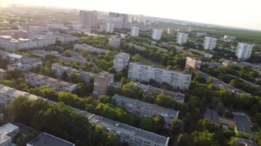Sunset fpv drone flight in summer green city, residential district near Sarzhyn Yar. Aerial cityscape above buildings and streets, Pavlovo Pole, Kharkiv Ukraine