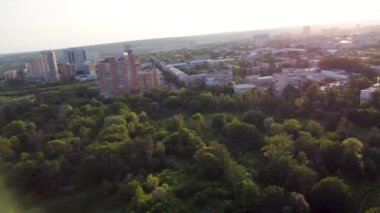 Sunset fpv drone flight in summer city, residential district near Sarzhyn Yar. Aerial cityscape above buildings and streets, Pavlovo Pole, Kharkiv Ukraine