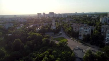 Sunset forward flight in summer city, residential district near Sarzhyn Yar. Aerial cityscape above buildings and streets, Pavlovo Pole, Kharkiv Ukraine