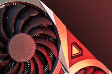 Cooler fan on Gpu graphics video card, close-up in red light, PC hardware details. Components from powerful modern personal computer