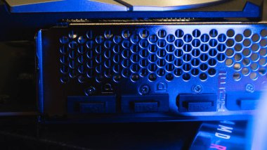 Kyiv, Ukraine - August 19, 2022: MSI MECH 2X graphics video card back ports metal panel in blue light, close-up
