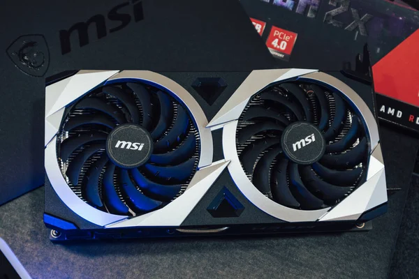 Kyiv, Ukraine - August 19, 2022: MSI MECH 2X graphics video card with AMD Radeon RX6700XT chipset unpacking in blue light, close-up with box