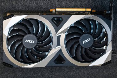 Kyiv, Ukraine - August 19, 2022: MSI MECH 2X graphics card with AMD Radeon RX6700XT GPU on board on black background, computer hardware components top view