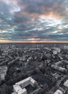 Gri tonlu Kharkiv şehri Pavlove Pole bölgesinde sonbahar havası. Çok katlı binalar. Canlı, renkli günbatımı gökyüzü.