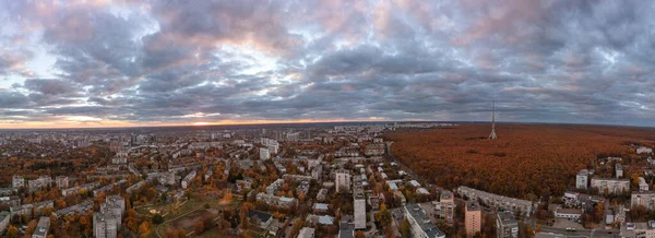 風光明媚な雲と地区の近くのカラフルな森の中で背の高いテレビ塔と秋の街の空中夕日のパノラマ ウクライナのハリコフ — ストック写真