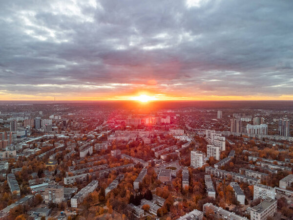 Sun shine in epic clouds. Aerial vivid autumn city sunset view. Residential district buildings in evening light. Kharkiv, Ukraine