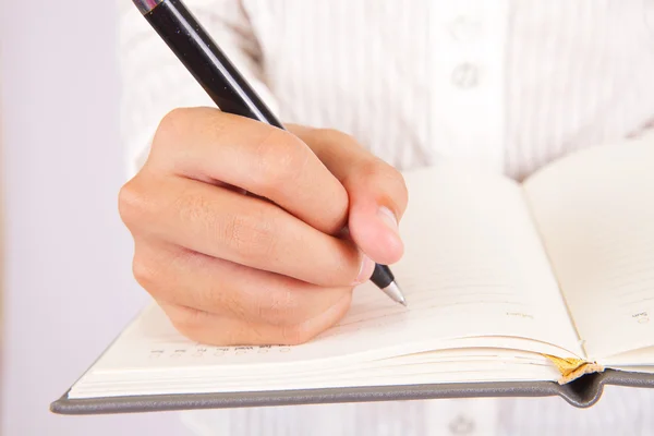 Bizneswoman pisze w swoim notatniku — Zdjęcie stockowe
