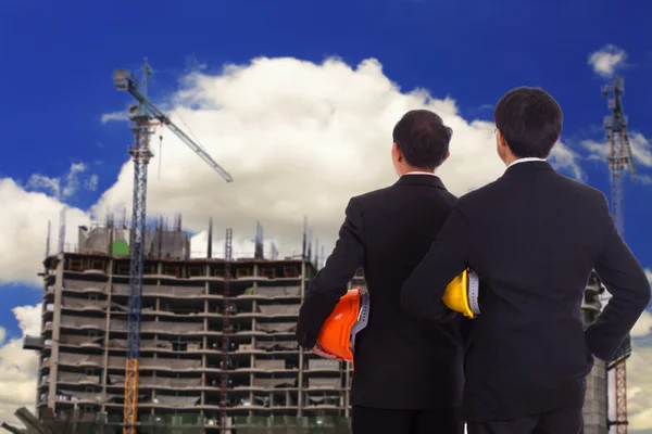 Construction engineers look at the construction of high-rise buildings — Stock Photo, Image