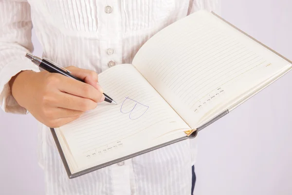 Bizneswoman pisze w swoim notatniku — Zdjęcie stockowe