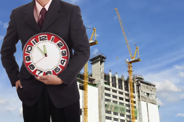 Businessman holding a big red clock — Stock Photo, Image