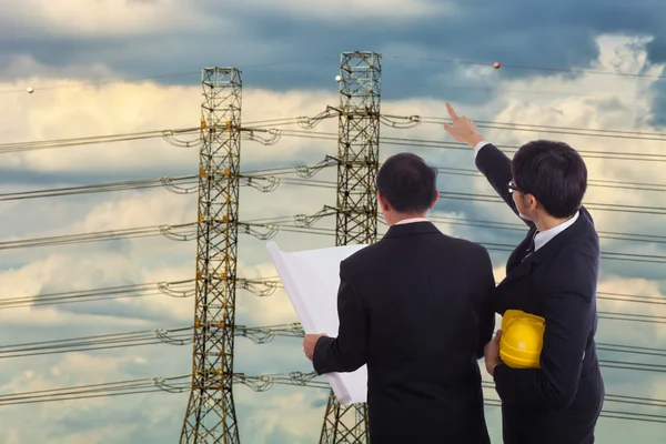 Two engineers on the background of high-voltage wires — Stock Photo, Image