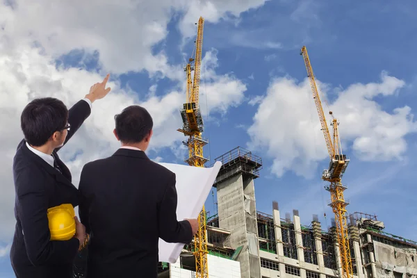 Dois engenheiros no fundo da construção — Fotografia de Stock