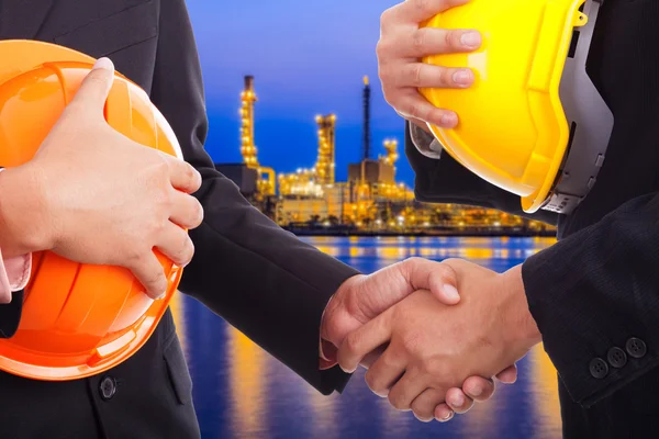 Businessmen shaking hands on a background of factory — Stock Photo, Image