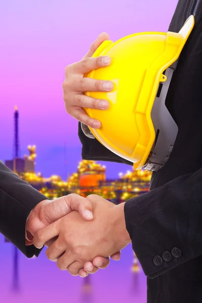 Businessmen shaking hands on a background of factory — Stock Photo, Image