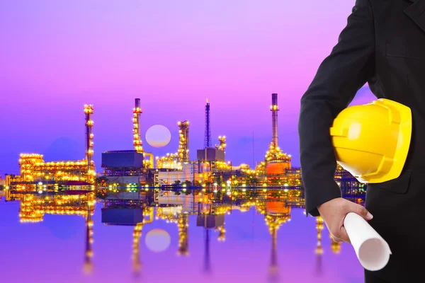 Construction engineer with a helmet on a background of a large plant — Stock Photo, Image