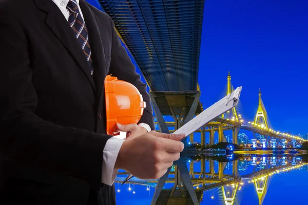 Engenheiro de construção com um capacete vermelho e documentos na mão — Fotografia de Stock