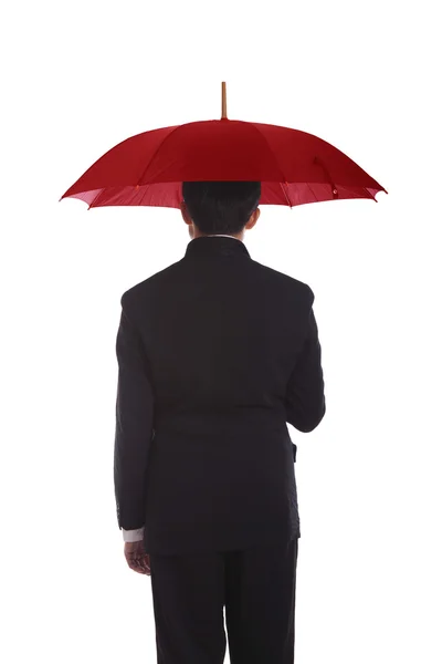 Affärsman som står under ett rött paraply — Stockfoto