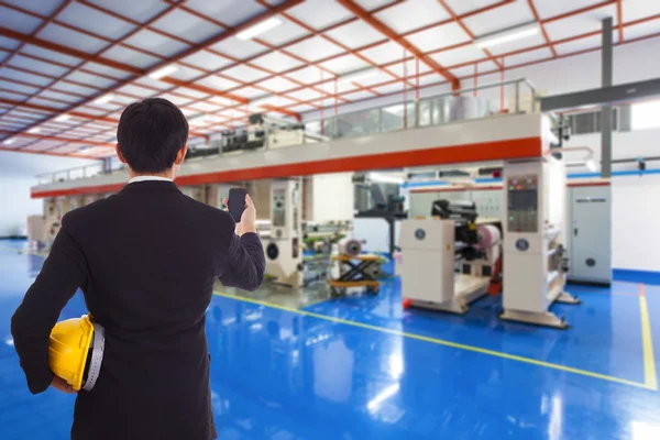 Zakenman met helm staan binnen de fabriek — Stockfoto