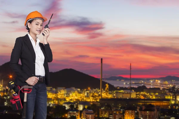 Asian woman engineer in orange helmet transmits by radio — Stock Photo, Image