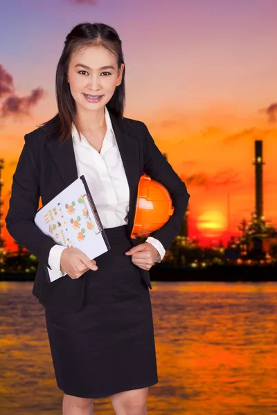 Ingeniera femenina sosteniendo un sombrero naranja y una carpeta con documentos — Foto de Stock