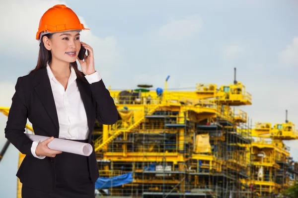 Engineer woman in an orange helmet talking on the phone — Stock Photo, Image