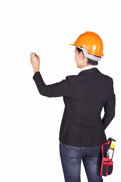 Female engineer with an orange helmet on her head writes on the wall — Stock Photo, Image