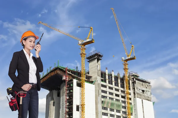 Mühendis kadın turuncu bir kask içinde radyo tarafından iletir. — Stok fotoğraf