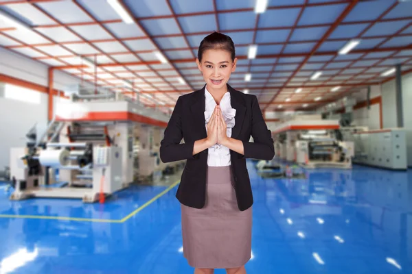 Businesswoman crossed her arms in front of her inside the factory