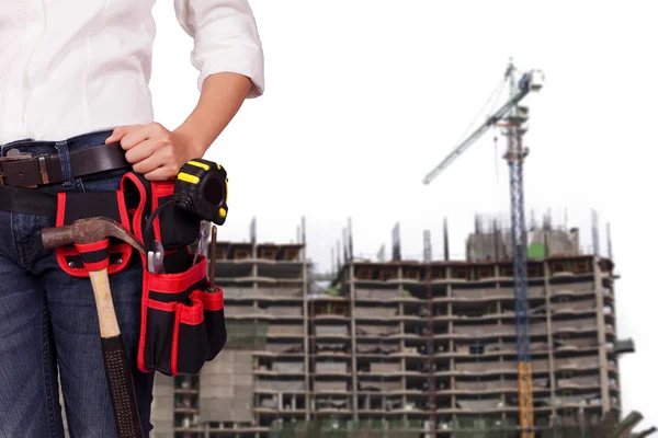 Female engineer standing against the background of an unfinished building — Stock Photo, Image