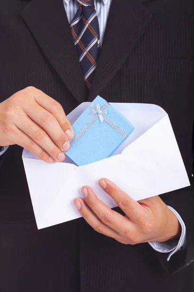 Uomo d'affari esce dalla busta una scatola con un regalo — Foto Stock