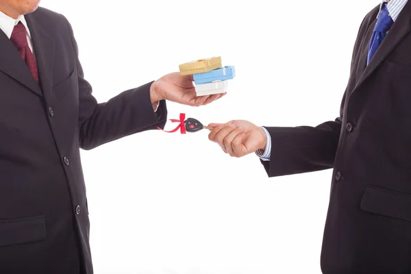 One businessman gives the keys to the car to another in exchange for a gift — Stock Photo, Image