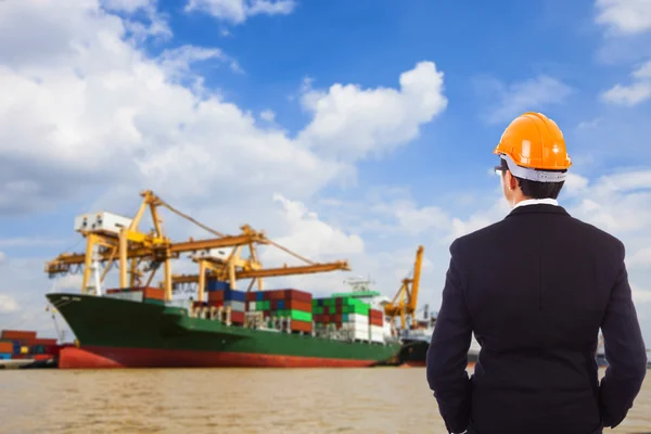 Geschäftsmann mit rotem Helm blickt auf Hafen — Stockfoto