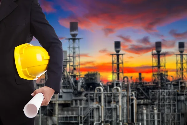 Man holding yellow helmet in the power plant background — Stock Photo, Image