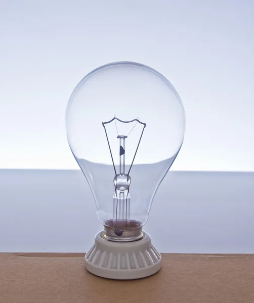 Close-up incandescent Light bulb blue gradient background — Stock Photo, Image