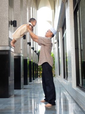 Mutlu Asyalı küçük çocuk Ramazan 'da babasıyla evde oynuyor.