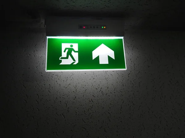 emergency exit sign in case of fire, glowing in the dark by electric lightin