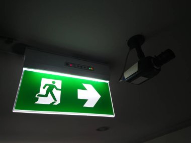 Yangın durumunda acil çıkış işareti, elektrik ışığıyla karanlıkta parlıyor.