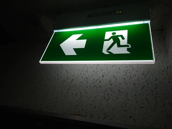 emergency exit sign in case of fire, glowing in the dark by electric lightin