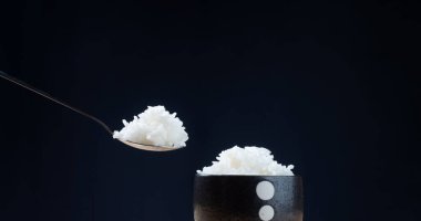 Koyu arkaplanda sıcak buharlı beyaz pilav, yemeye hazır.