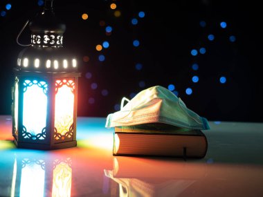 Müslüman tarzı fenerin maske ve Kur 'an kitabında parlayan mum ışığı kapakları, Ramazan Kareem Mubara' yı selamlamak için kullanın.